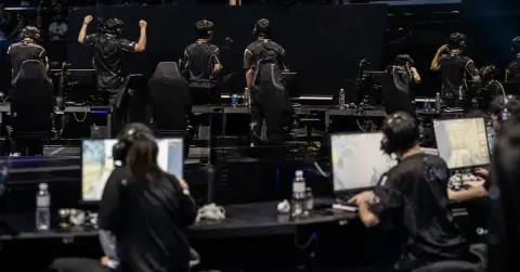 Anonymous esports players react after a close match in a crowded arena