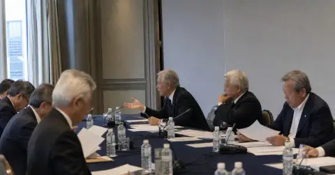 Anonymous football officials meet in Tokyo conference room over governance papers.