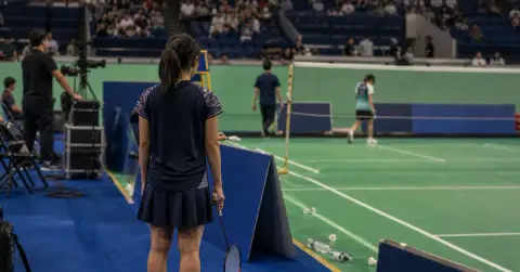An anonymous badminton player waits courtside after a French Open match.