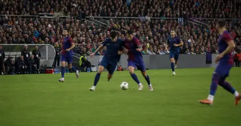 Anonymous footballers contest the ball during a crowded European night match.