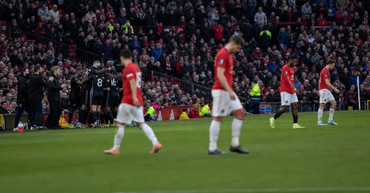Away players celebrate while dejected home players leave the pitch