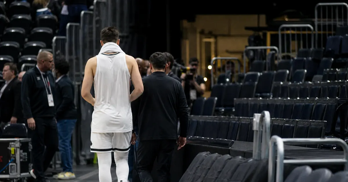 Anonymous basketball player walks toward an arena tunnel after a game.