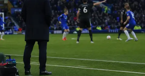 Anonymous captain gestures during a tense match at a crowded stadium.
