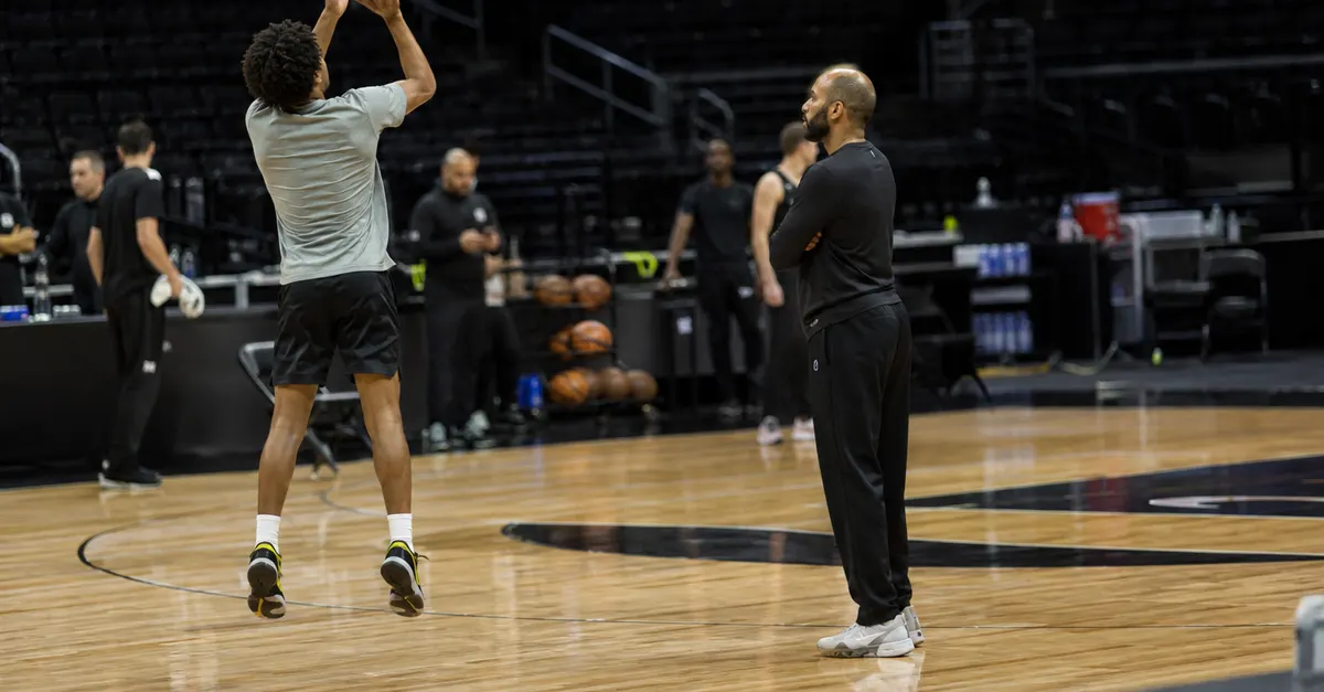 Anonymous basketball guard practices jump shots on a quiet court.