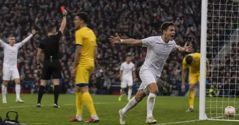 Anonymous footballer celebrates as referee shows opponent a red card
