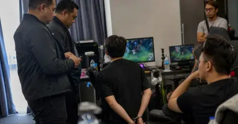 Plainclothes officers speak with an esports player at a gaming bootcamp.