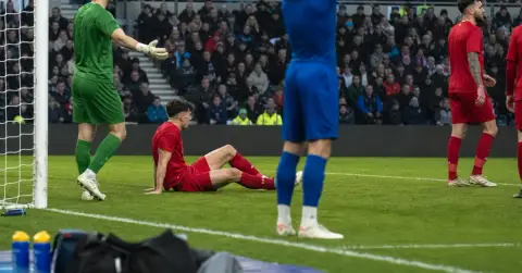 Players react after a missed chance during a closely contested football match.