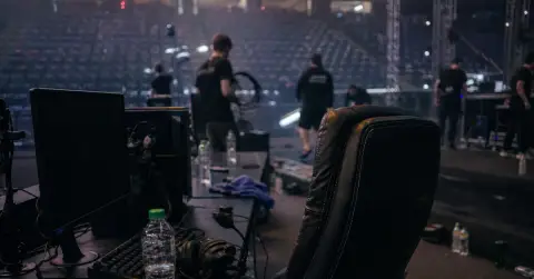 Empty esports commentary desk with a headset in a quiet arena.