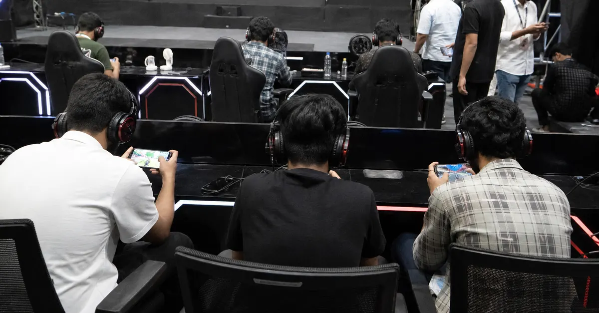 Anonymous mobile gamers compete at stations inside a modest esports arena.