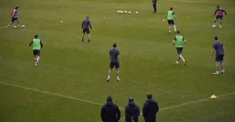 Young footballers practise wide roles as a centre-forward waits centrally