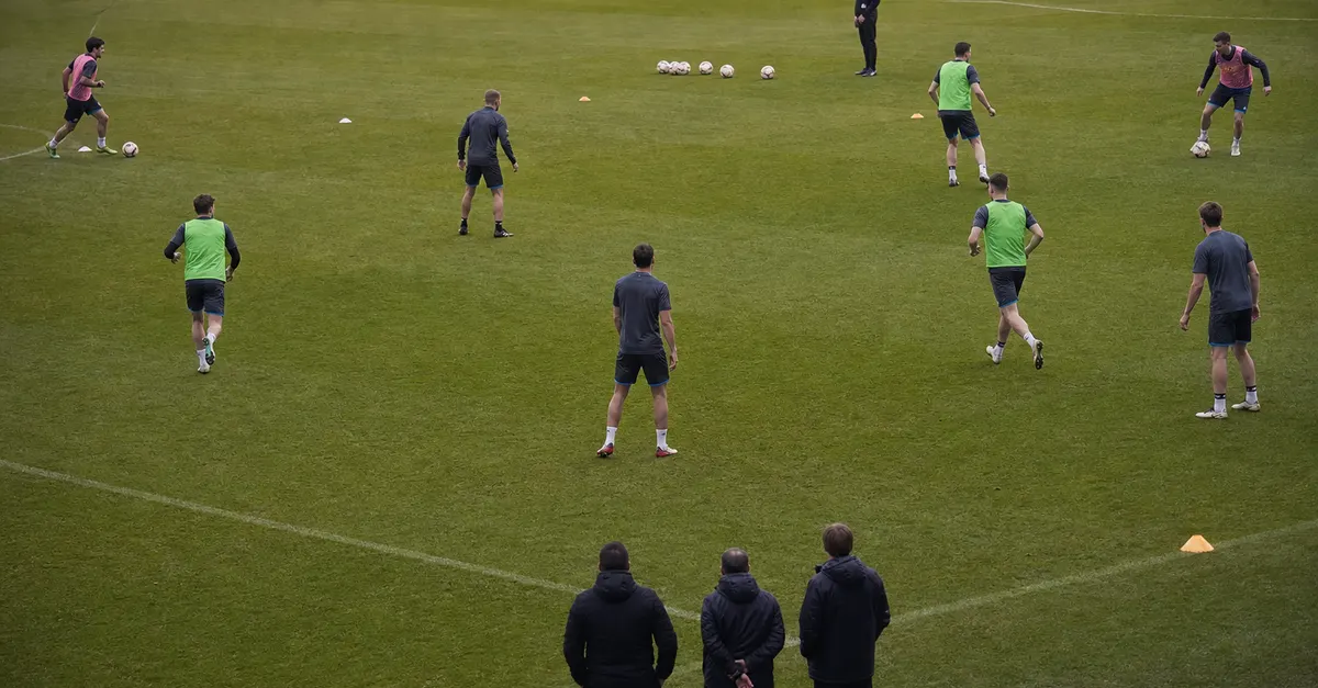 Young footballers practise wide roles as a centre-forward waits centrally