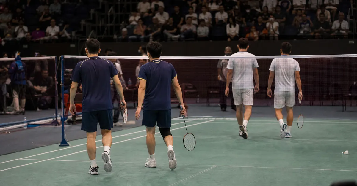 Anonymous badminton players leave court after a difficult tournament campaign.