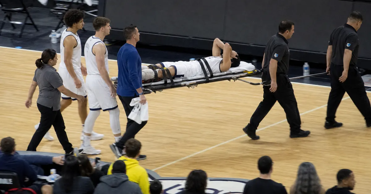 Injured basketball player carried from court on a stretcher