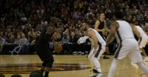 Anonymous basketball players compete during a crowded opening-night arena game.