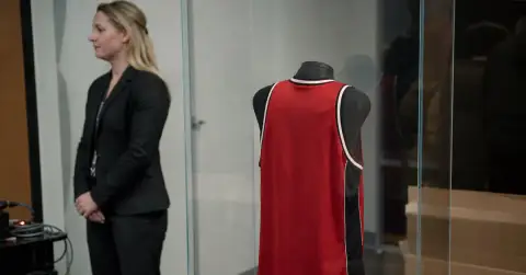 Vintage basketball jersey displayed behind glass at a private memorabilia viewing