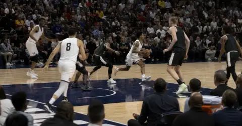 Anonymous basketball players race through a fast-paced professional game.