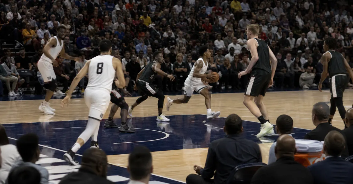Anonymous basketball players race through a fast-paced professional game.