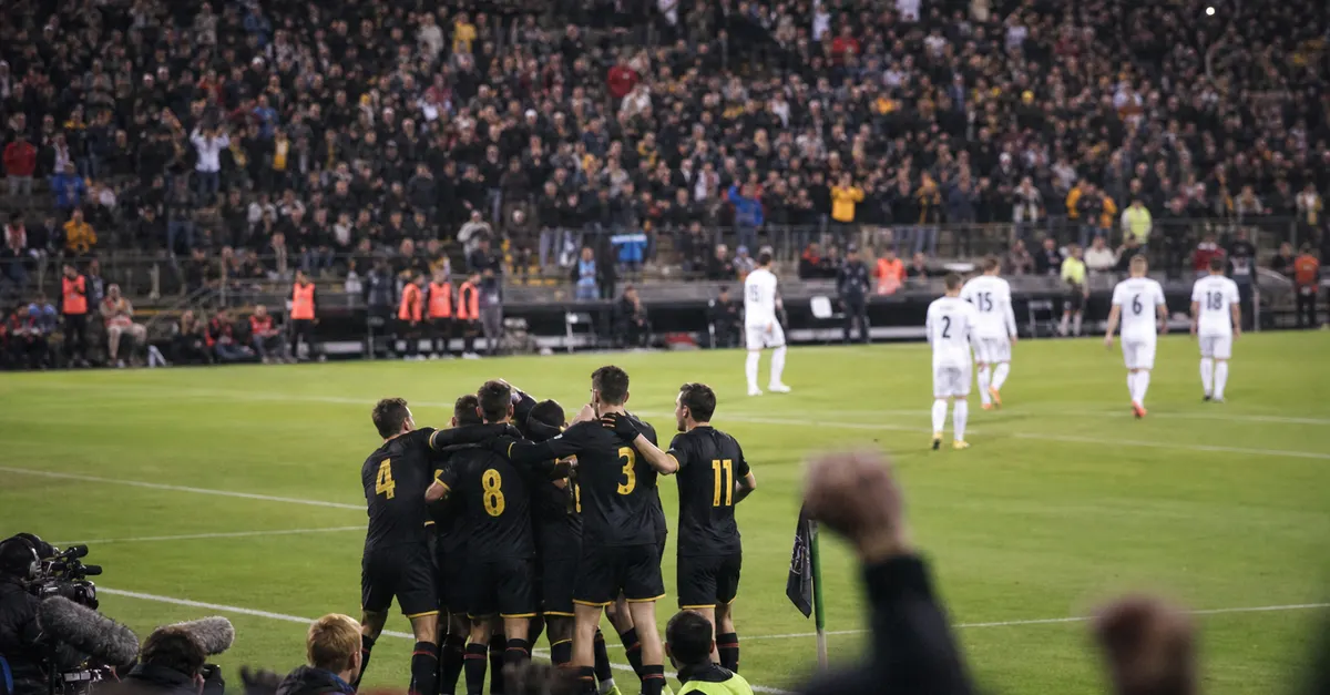 Anonymous footballers celebrate a late comeback as opponents leave the pitch.