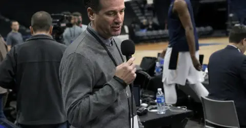 A basketball reporter speaks during a subdued arena media scrum.