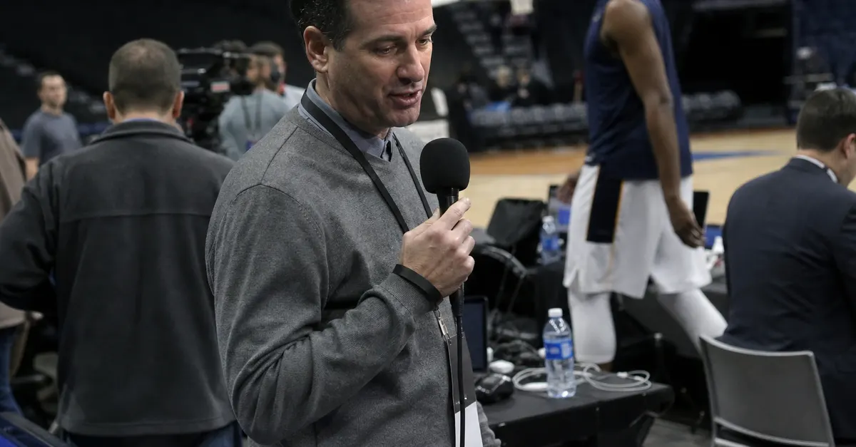 A basketball reporter speaks during a subdued arena media scrum.