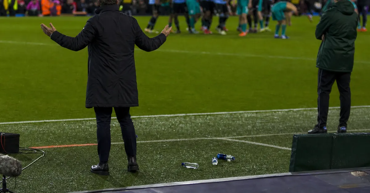 Anonymous coach reacts on touchline as players leave after dramatic football match