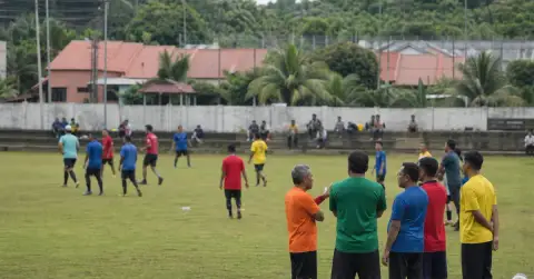 Adult players and coaches gather for a shared community football training session.