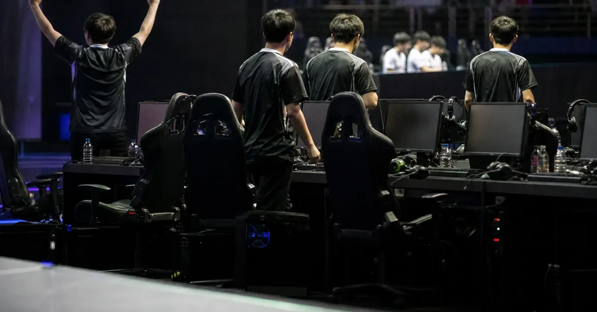Anonymous esports players celebrate a semifinal victory beside gaming PCs