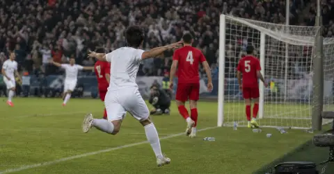 Anonymous footballers react after a goal during a European match.