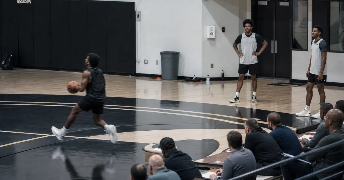 Anonymous basketball prospects work out as scouts observe from the stands.