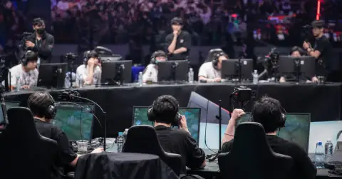 Anonymous esports players compete under arena lights during a tense elimination match.