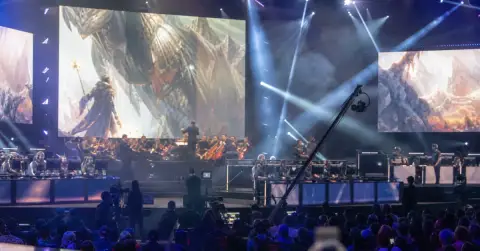 Anonymous performers and esports players share a brightly lit arena stage