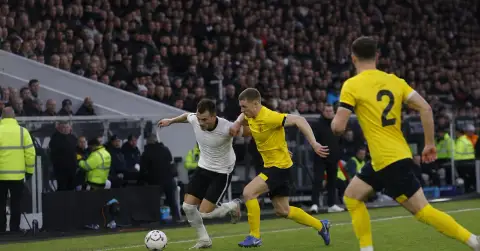 Anonymous footballers contest the ball during a tense league match.