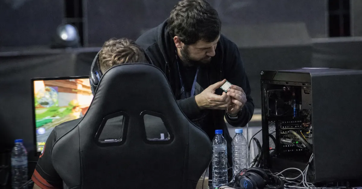 Anonymous esports player and technician inspect an open gaming computer