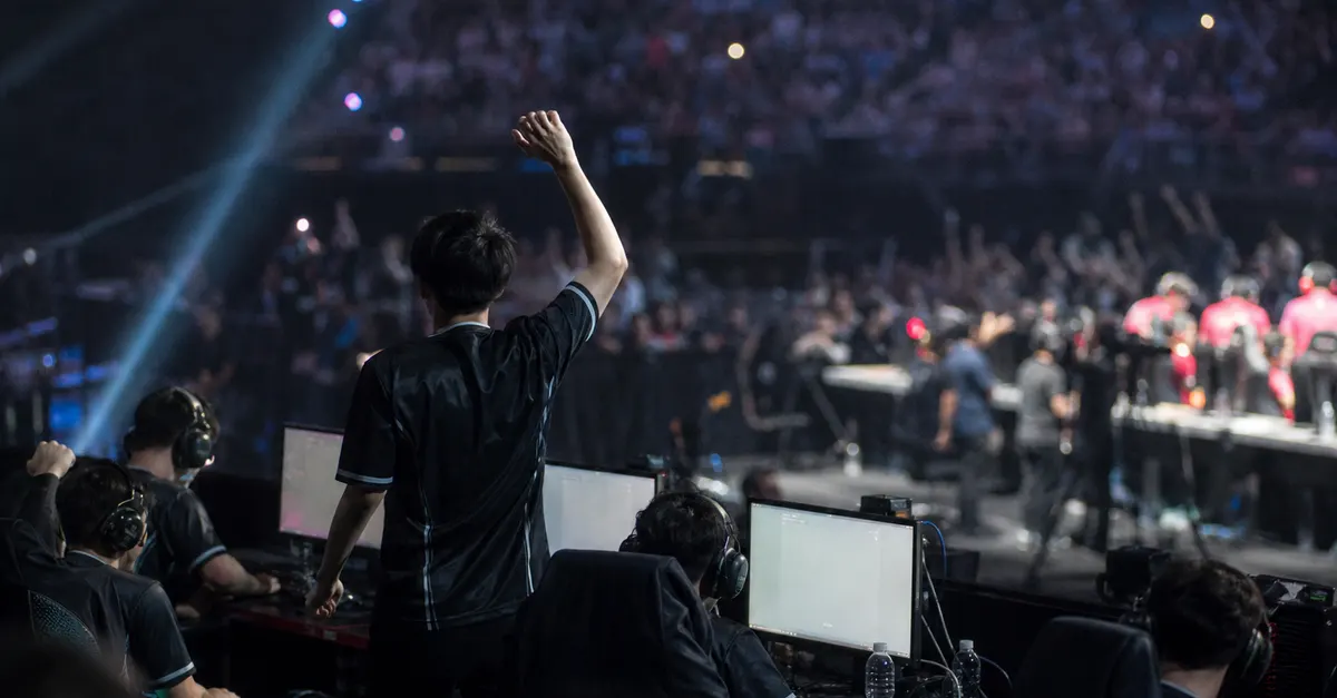Anonymous esports players celebrate a tournament win beside gaming PCs