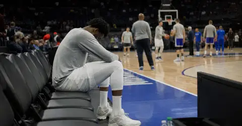 Anonymous basketball player sits apart on the bench during warmups