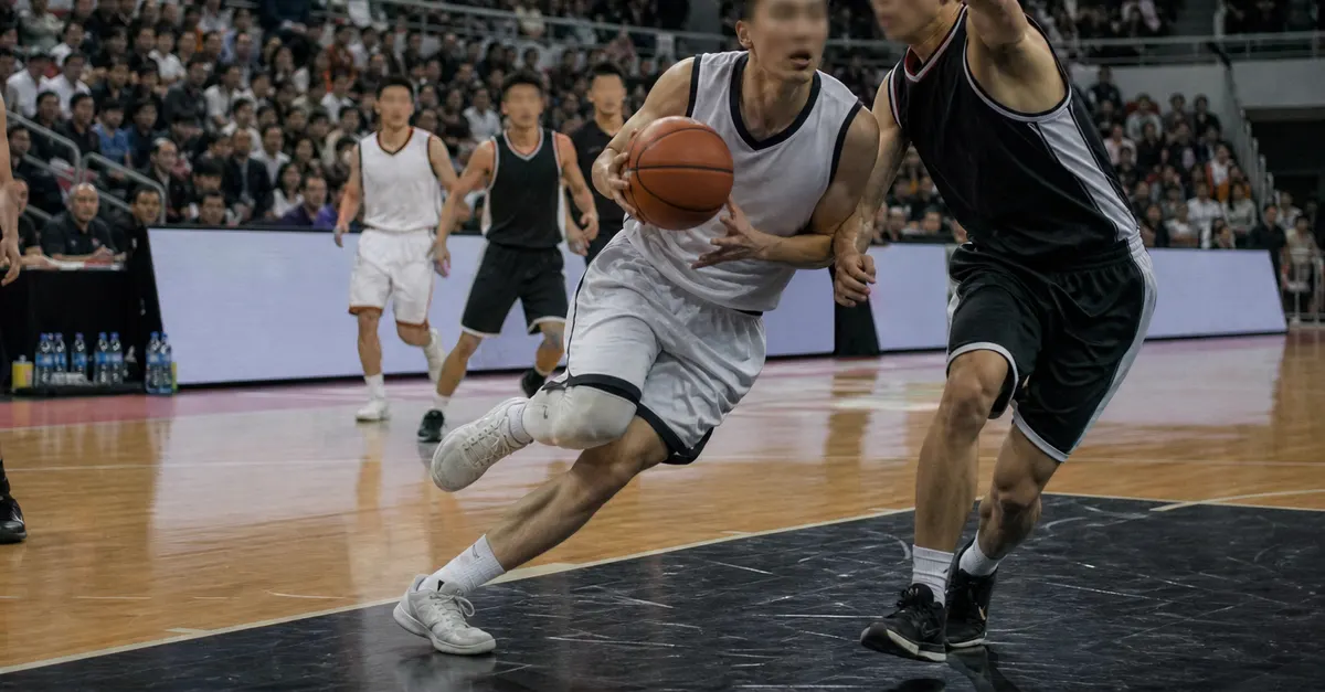 Anonymous rookie drives toward the basket during a crowded basketball game.