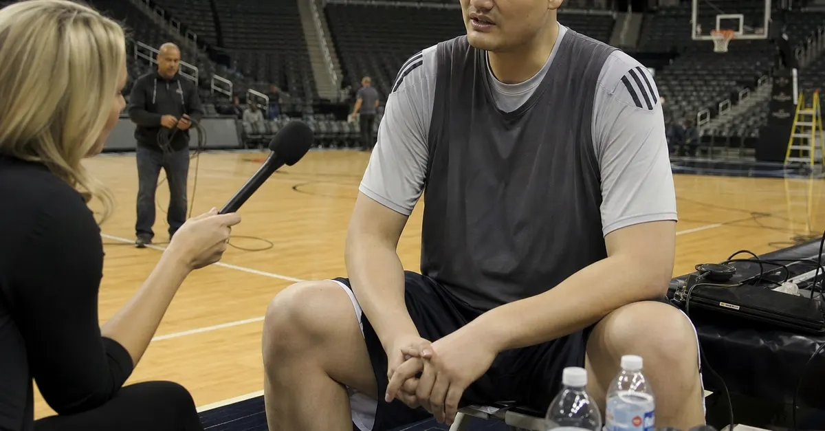 Anonymous tall basketball player speaks calmly during a courtside interview.