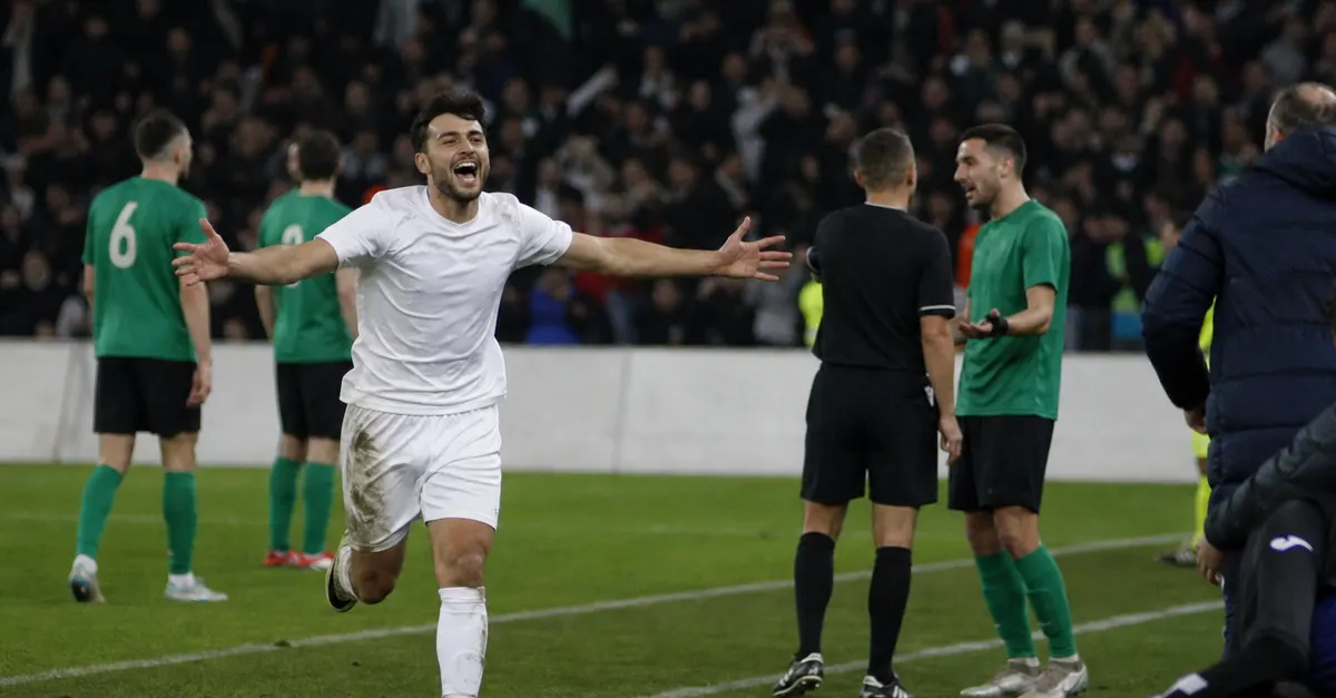 Anonymous forward celebrates after a high-scoring league match under stadium lights.
