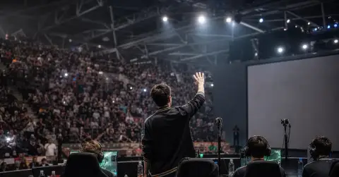 Anonymous esports players celebrate at their computers after a major final.